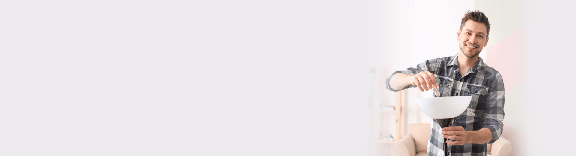 Mann wechselt eine Glühbirne in einer Stehlampe und freut sich über einfachen Stromwechsel